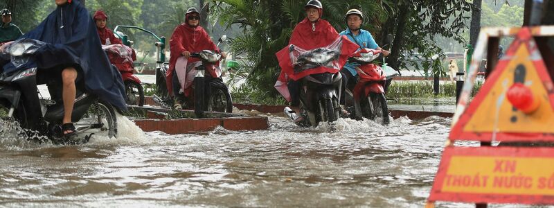 In Hanoi bahnten sich viele Motorradfahrer ihren Weg durch die Wassermassen. - Foto: Huy Han/AP/dpa