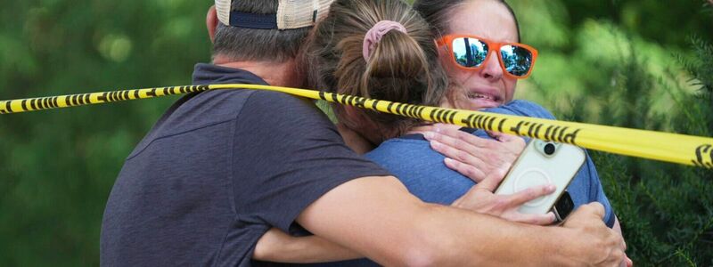Menschen umarmen sich nach Schüssen an einer Schule, bei denen zwei Kinder gestorben sind. - Foto: Alex Kormann/Star Tribune/AP/dpa