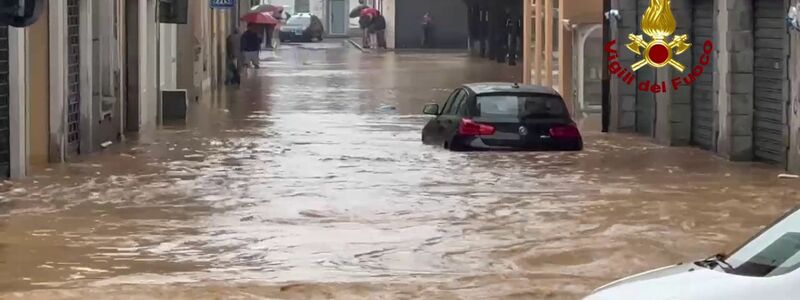 In der Stadt Cabiate zwischen Mailand und dem Comer See fließt das Wasser kniehoch durch die Straßen. - Foto: -/Vigili del Fuoco/dpa