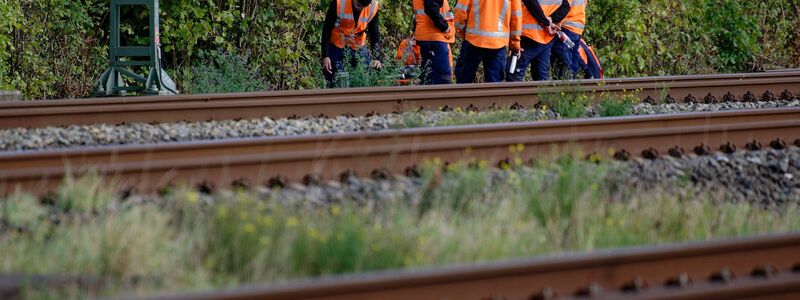 Bahn-Mitarbeiter stehen am Rand der Strecke Köln-Düsseldorf.  - Foto: Henning Kaiser/dpa