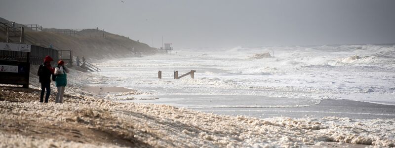 Sturmflut vor Sylt. Das Wetter lockte auch Spaziergänger an die Nordsee. - Foto: Daniel Bockwoldt/dpa
