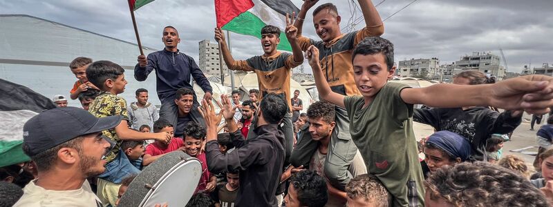 Palästinenser feiern im Lager Nusairat nach der Bekanntgabe, dass Israel und die Hamas der ersten Phase eines Friedensplans zur Unterbrechung der Kämpfe zugestimmt haben. - Foto: Belal Abu Amer/APA Images via ZUMA Press Wire/dpa