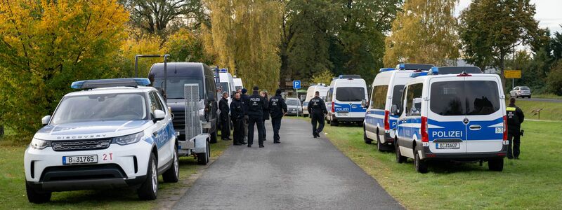 Polizisten stehen vor einem Grundstück in Tauche. - Foto: Christophe Gateau/dpa