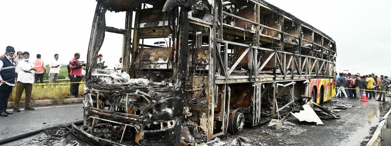 Die verkohlten Überreste des Passagierbusses liegen auf einer Landstraße im Dorf Chinnatekuru. - Foto: -/AP/dpa