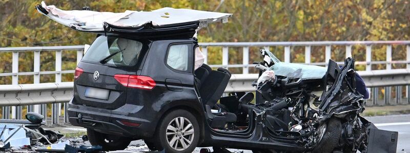 Der schwarze Pkw wurde völlig zerstört. Das Dach des Wagens ist größtenteils abgerissen. - Foto: Swen Pförtner/dpa
