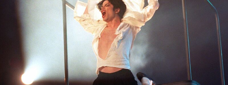Michael Jackson am Geländer der Hebebühne in der Duisburger Rhein-Ruhr-Halle am Abend des 4. November 1995. (Archivbild) - Foto: Achim Scheidemann/dpa