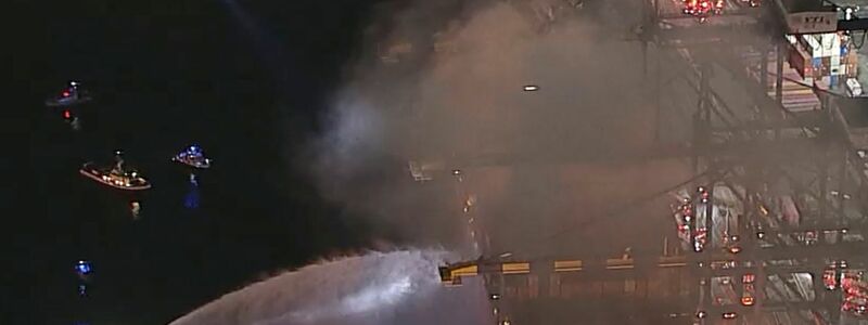 Der Brand unter Deck ist schwer zu bekämpfen, weil die Hitze für die Einsatzkräfte zu groß ist. Gefahr geht auch von der betroffenen Fracht aus.  - Foto: Uncredited/ABC7/AP/dpa