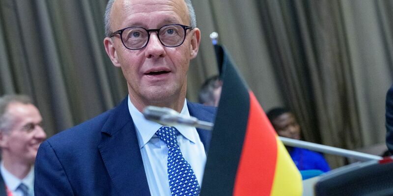 Kanzler Friedrich Merz (CDU) äußert sich in der angolanischen Hauptstadt Luanda auch zu den Verhandlungen über einen Friedensplan für die Ukraine. - Foto: Michael Kappeler/dpa-Pool/dpa