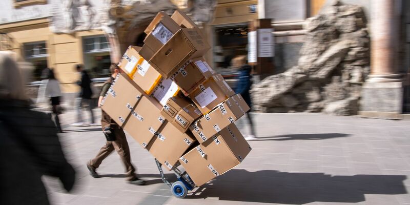 Ganz schön viel zu tun: ein Paketbote bei der Arbeit. - Foto: Peter Kneffel/dpa