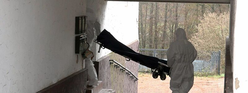 Beamte der Spurensicherung bringen eine Trage in ein Wohnhaus.  - Foto: Thorsten Kremers/dpa