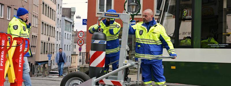 Zu den Hauptverkehrszeiten müssen Sicherheitsmitarbeiter neben dem Augsburger Christkindlesmarkt jede Stunde dutzendfach schwere Poller bewegen, damit die Straßenbahnen durchfahren können. - Foto: Malin Wunderlich/dpa