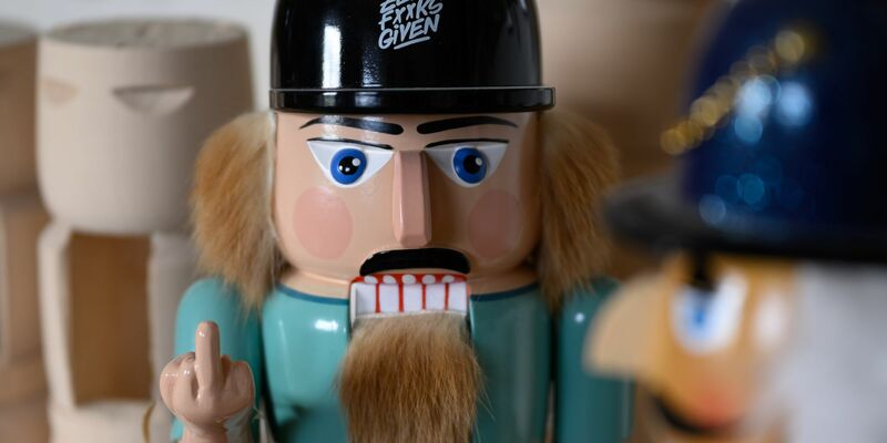 Hölzerner Rebell: Der erzgebirgische Nussknacker zeigt Billigkopien aus Fernost den Stinkefinger.  - Foto: Hendrik Schmidt/dpa