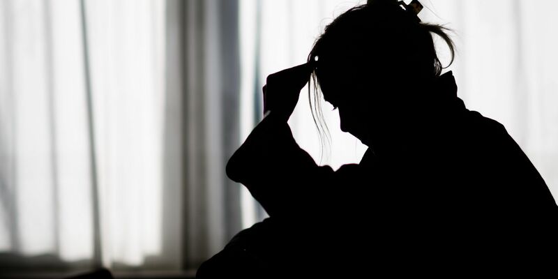 Silhouette einer Frau vor einer hellen Fensterfront - Foto: Julian Stratenschulte/dpa