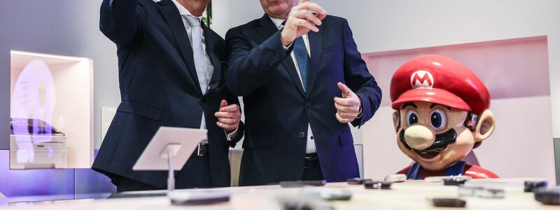 Nicht nur Kulturstaatsminister Wolfram Weimer und der Präsident der Stiftung Haus der Geschichte, Harald Biermann, können nun rätseln, welche Handy sie noch kennen. - Foto: Oliver Berg/dpa