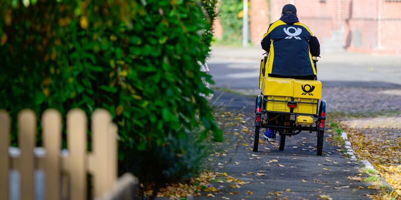 Ein Briefträger bei der Arbeit. - Foto: Philipp Schulze/dpa