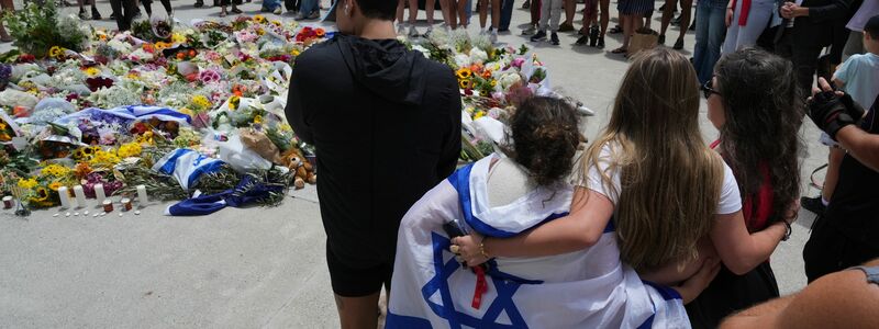 Zahlreiche Menschen legen am Tatort Blumen nieder. - Foto: Mark Baker/AAP/dpa