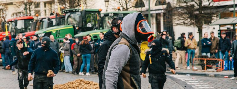Demonstranten und Bereitschaftspolizei stehen vor dem Eingang des Europäischen Parlaments. - Foto: Emile Windal/Belga/dpa