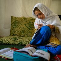 Die zehnjährige Hajira aus der afghanischen Provinz Nangarhar sitzt in einem Haus in einem abgelegenen Dorf östlich von Kabul über Schulbüchern und lernt.  - Foto: Elise Blanchard/Unicef/dpa
