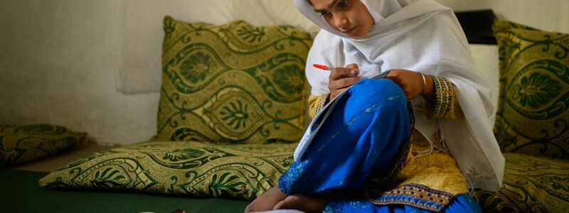 Die zehnjährige Hajira aus der afghanischen Provinz Nangarhar sitzt in einem Haus in einem abgelegenen Dorf östlich von Kabul über Schulbüchern und lernt. - Foto: Elise Blanchard/Unicef/dpa
