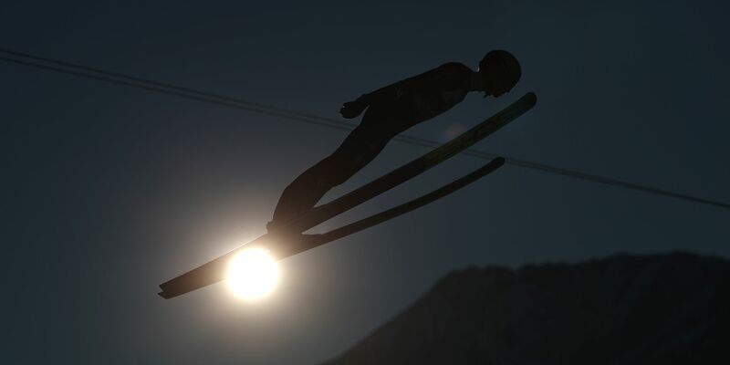 Raimund trägt seine Ski in Obertstdorf. - Foto: Daniel Karmann/dpa