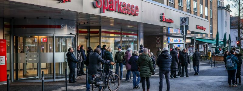 Polizisten sichern den Eingang der Sparkassenfiliale in Gelsenkirchen-Buer, nachdem wartende Kunden versucht hatten in die Bank zu gelangen. - Foto: Christoph Reichwein/dpa