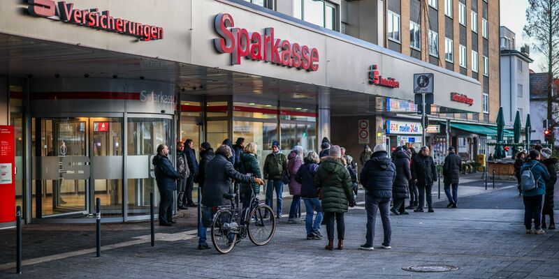 Nach einem Einbruch in den Tresorraum einer Bankfiliale in Gelsenkirchen warten Menschen vor dem Eingang auf Informationen. - Foto: Christoph Reichwein/dpa