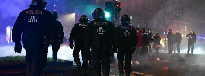 Feuerwerk brennt während der Silvesternacht in Neukölln vor einem Polizeiauto. - Foto: Sebastian Christoph Gollnow/dpa