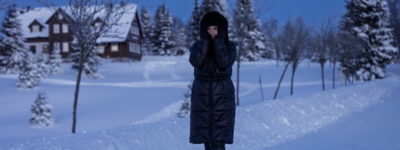 Eine Frau spaziert durch eine verschneite Landschaft in Tschechien. - Foto: Radek Petrášek/CTK/dpa
