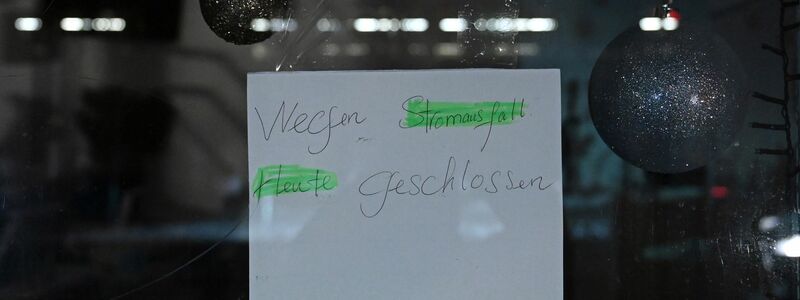 In einem Schaufenster in Zehlendorf hängt ein Schild mit dem Hinweis, dass derzeit wegen Stromausfall kein Ladenbetrieb stattfindet. - Foto: Elisa Schu/dpa