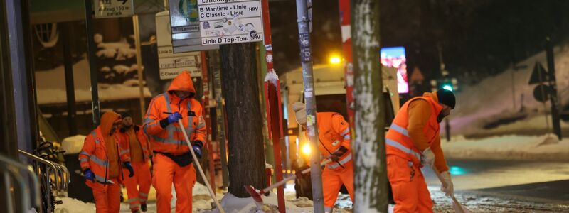 Mitarbeiter schieben Schnee von einem Bahnsteig am Hamburger Hauptbahnhof. - Foto: Christian Charisius/dpa