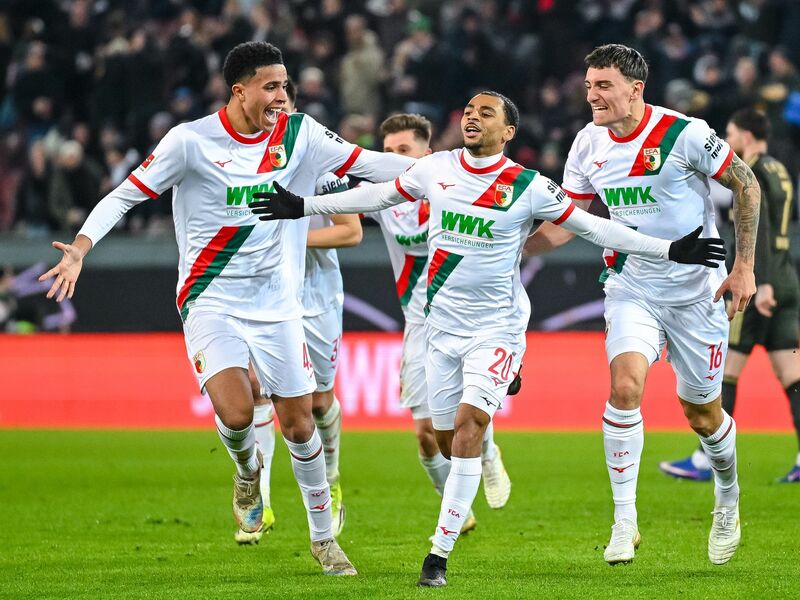Spieler und Ordner sammeln nach dem Fanprotest Gegenstände vom Rasen. - Foto: Harry Langer/dpa