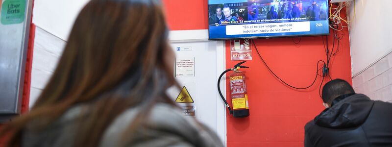 Menschen verfolgten die Berichte über das Unglück vor dem Fernseher. - Foto: Gustavo Valiente/XinHua/dpa
