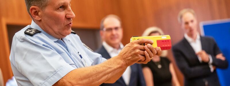 Ein Polizist erklärte die Funktionsweise eines Distanz-Elektroimpulsgeräts im vergangenen Jahr im Innnenministerium. (Archivfoto) - Foto: Michael Kappeler/dpa