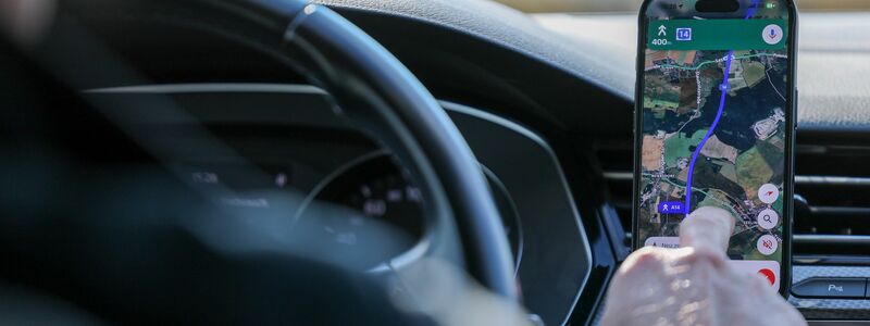So ist es derzeit erlaubt: Das Handy steckt in der Halterung und wird nur kurz vom Fahrer beachtet. (Symbolbild) - Foto: Jan Woitas/dpa
