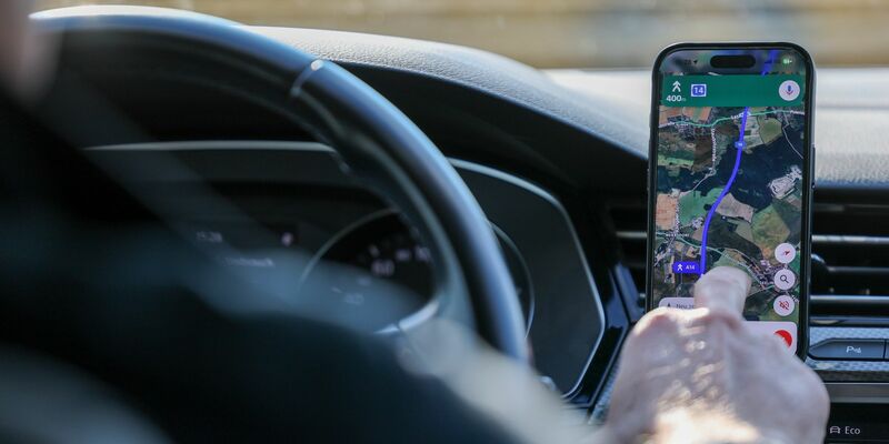 So ist es derzeit erlaubt: Das Handy steckt in der Halterung und wird nur kurz vom Fahrer beachtet. (Symbolbild) - Foto: Jan Woitas/dpa