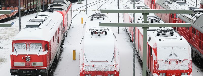 Im Bahnhof in Halle an der Saale sind die Lokomotiven mit Schnee bedeckt. - Foto: Hendrik Schmidt/dpa