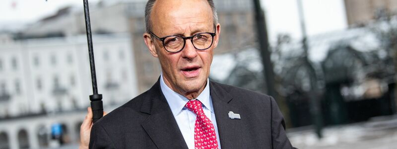 Gut beschirmt: Kanzler Merz. - Foto: Daniel Bockwoldt/dpa