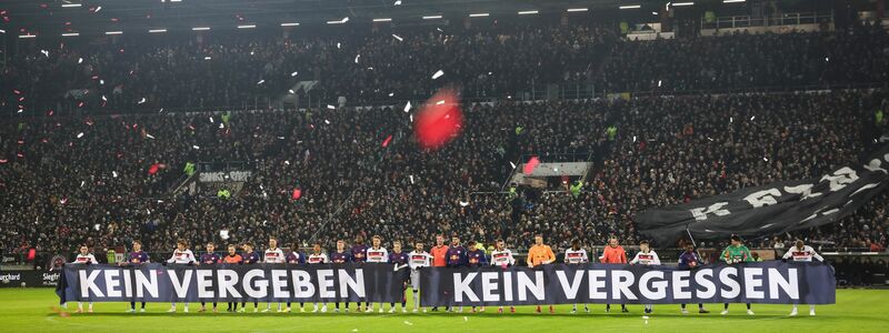 Spieler beider Teams halten vor Spielbeginn ein Banner anlässlich das Holocaust-Gedenktags hoch. - Foto: Christian Charisius/dpa
