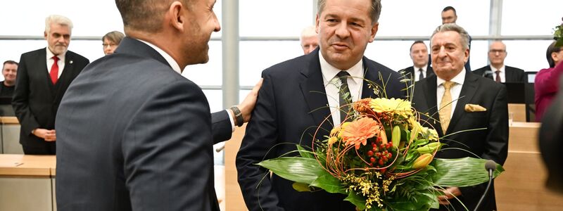 Sven Schulze bekommt Glückwünsche und einen Blumenstrauß vom AfD-Spitzenkandidaten Ulrich Siegmund.  - Foto: Hendrik Schmidt/dpa