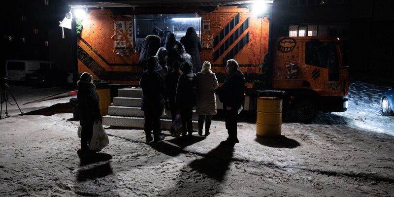 In Kiew stehen Bürger für warme Mahlzeiten Schlange, da es in vielen Häusern weder Strom noch Fernwärme gibt. - Foto: Danylo Antoniuk/AP/dpa