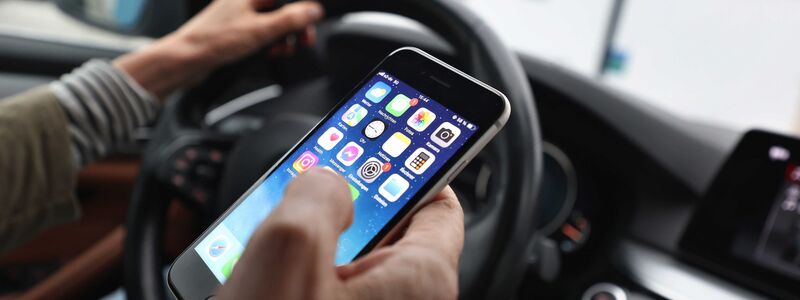 Ein «kurzer» Blick auf das Handy ist bisher erlaubt - wenn man es nicht in die Hand nimmt. (Symbolbild) - Foto: Karl-Josef Hildenbrand/dpa