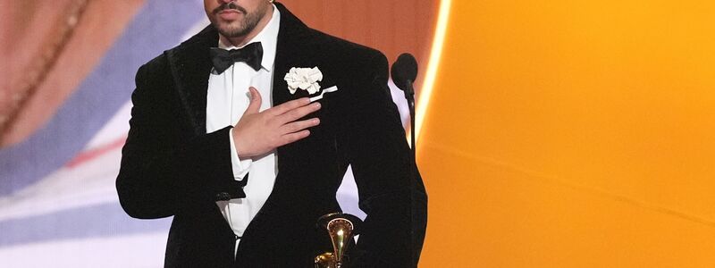 Bad Bunny nimmt den Preis für das Album des Jahres für «DeBÍ TiRAR MáS FOToS» bei den Grammy Awards entgegen ? und zeigt dabei, wo seine Heimat Puerto Rico liegt. (Archivbild) - Foto: Chris Pizzello/Invision/AP/dpa