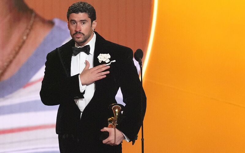 Bad Bunny nimmt den Preis für das Album des Jahres für «DeBÍ TiRAR MáS FOToS» bei den Grammy Awards entgegen ? und zeigt dabei, wo seine Heimat Puerto Rico liegt. (Archivbild) - Foto: Chris Pizzello/Invision/AP/dpa