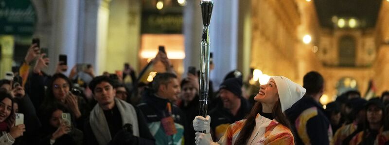 Das olympische Feuer ist bereits in Mailand, Balletttänzerin Nicoletta Manni trägt die Fackel. - Foto: Francisco Seco/AP/dpa