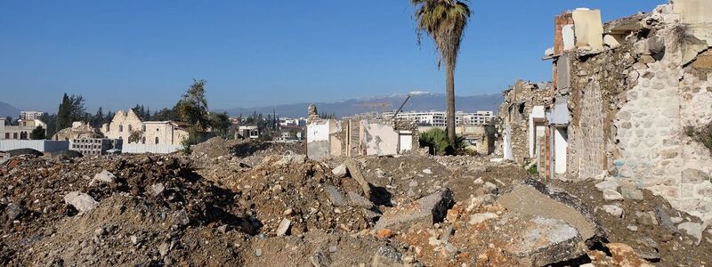 Links ist die Fassade der Kirche inmitten der Zerstörung zu sehen. - Foto: Mirjam Schmitt/dpa