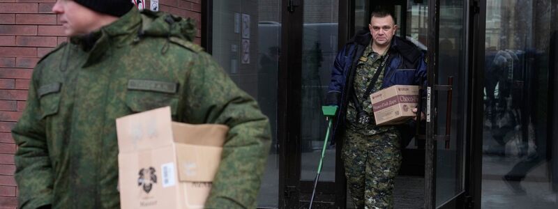 Ermittler verlassen das Gebäude, in dem die Schüsse auf den General abgefeuert wurden - er selbst liegt im Krankenhaus. - Foto: Pavel Bednyakov/AP/dpa