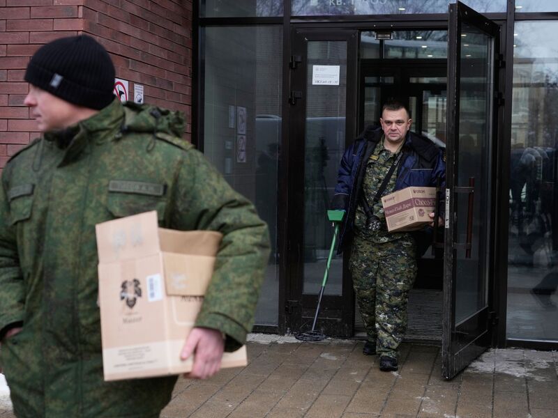 Ermittler verlassen das Gebäude, in dem die Schüsse auf den General abgefeuert wurden - er selbst liegt im Krankenhaus. - Foto: Pavel Bednyakov/AP/dpa