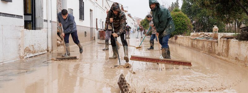 Menschen im südspanischen Andalusien reinigen Straßen nach dem Sturmtief Leonardo. Am Samstag folgte schon das nächste Atlantiktief Marta. - Foto: Álex Cámara/EUROPA PRESS/dpa
