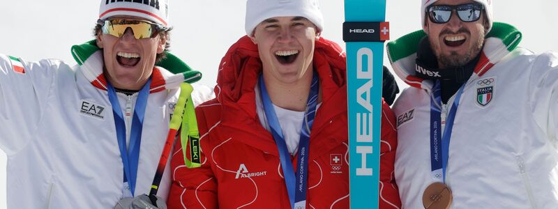 Olympiasieger Franjo von Allmen wird flankiert von Silber-Gewinner Giovanni Franzoni (links) und dem Drittplatzierten Dominik Paris. - Foto: Oliver Weiken/dpa