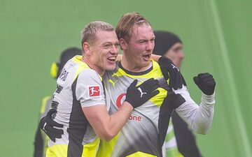 Julian Brandt (r) jubelt mit Julian Ryerson über seinen Treffer. - Foto: David Inderlied/dpa